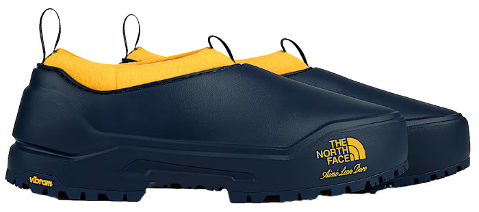 A pair of navy The North Face slip-on shoes with yellow lining.