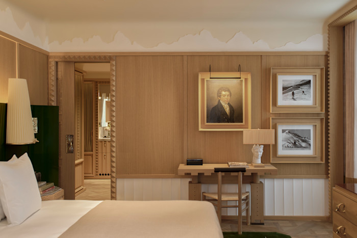 A hotel bedroom with framed pictures on the wall