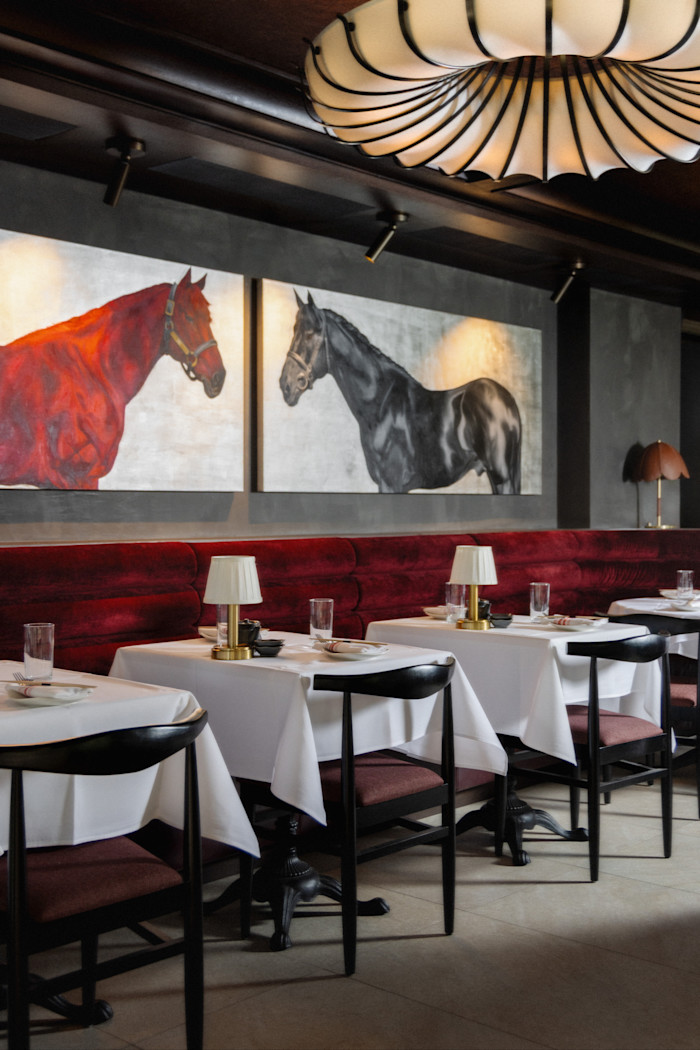 A restaurant with two paintings of horses