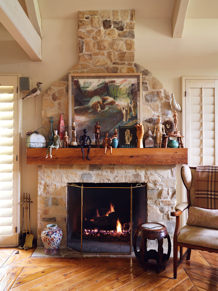 A 1992 Jerald Silva portrait of the Raymonds’ dog Nicky hangs above the fireplace in the main bedroom. Collections of antique French artists’ models and articulated hands line the mantelpiece