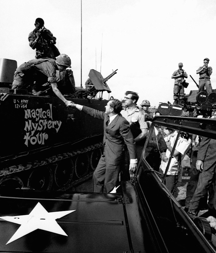 President Richard Nixon shakes hands with a soldier on a US Army tank labelled "Magical Mystery Tour" while visiting troops in Vietnam.