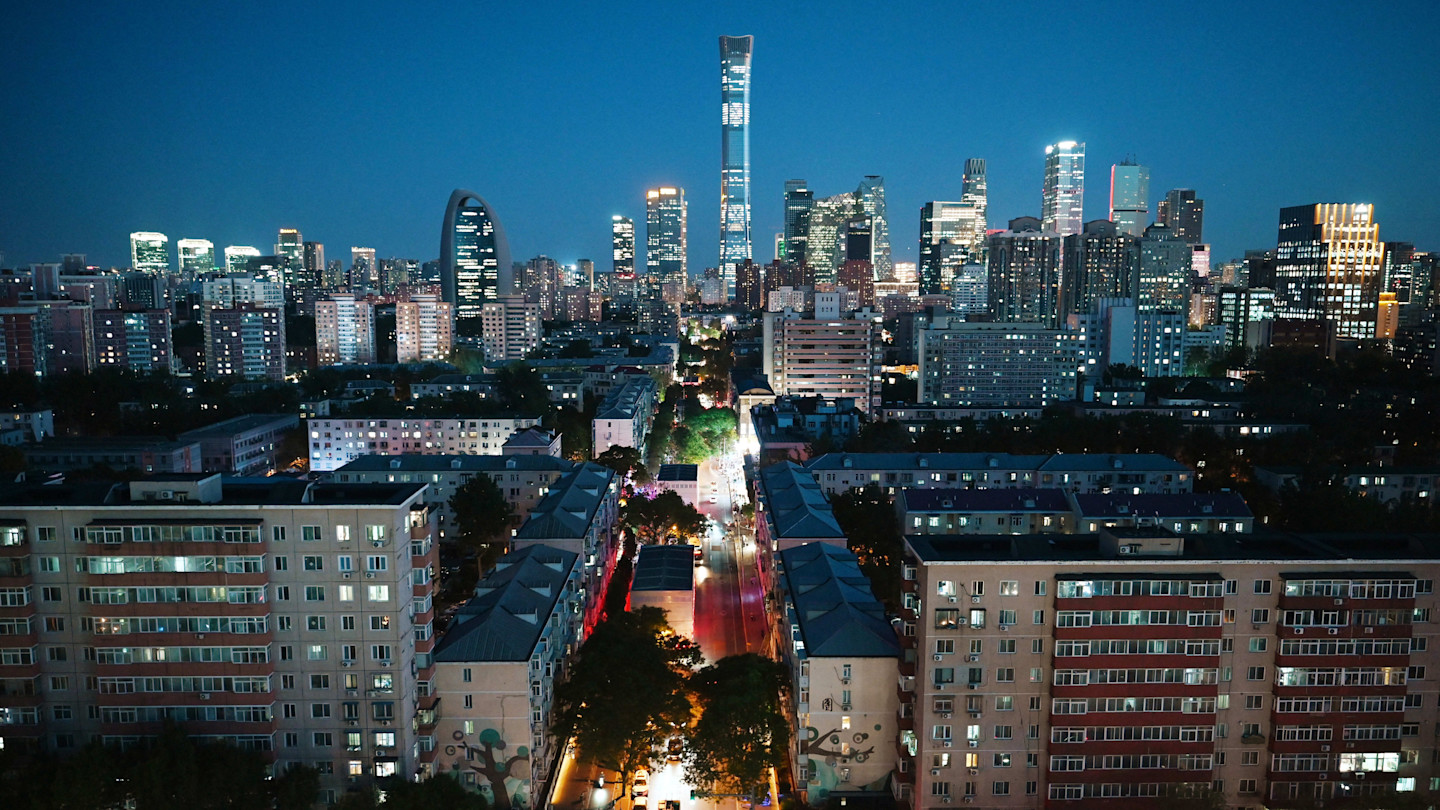 China Zun and other skyscrapers illuminated at dusk in Beijing’s central business district, with city lights visible.