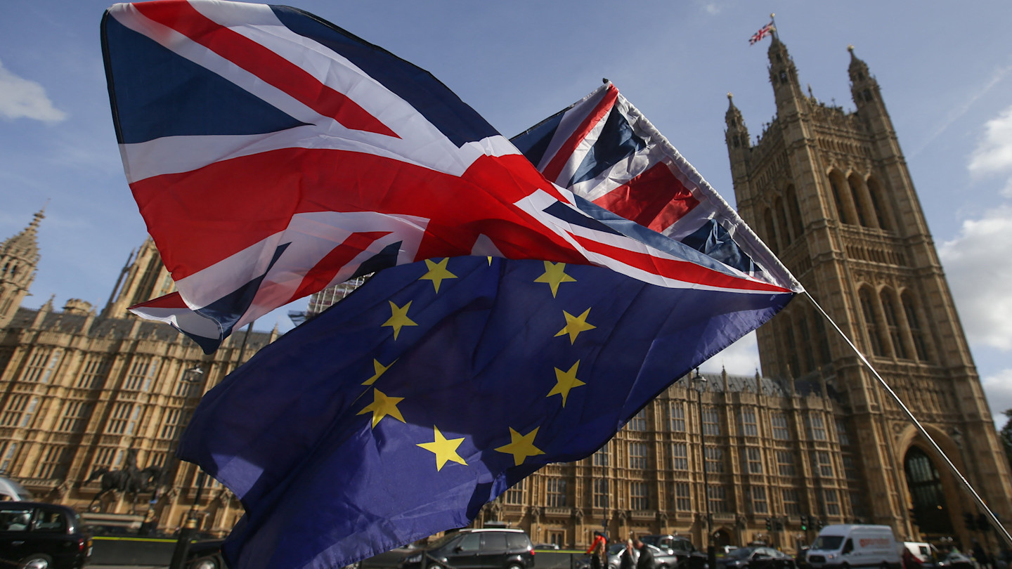 A Union flag and an EU flag held outside the Houses of Parliament during a Brexit demonstration.