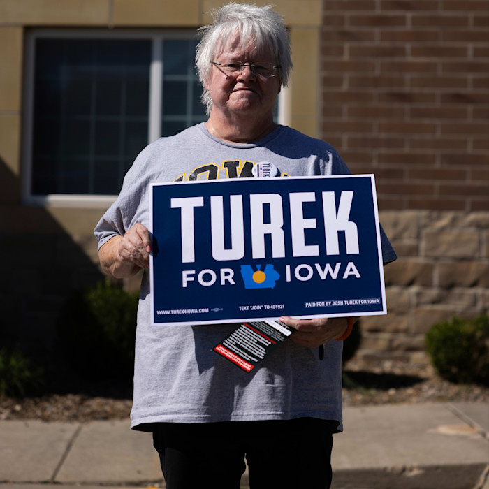 A woman holds a sign that reads ‘Turek for Iowa’