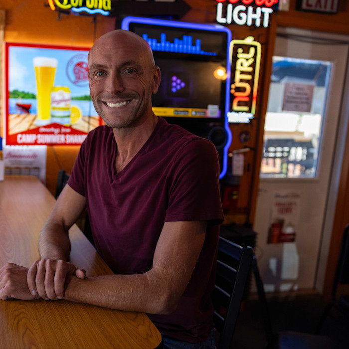 A smiling Mike Pearson sits in a pub