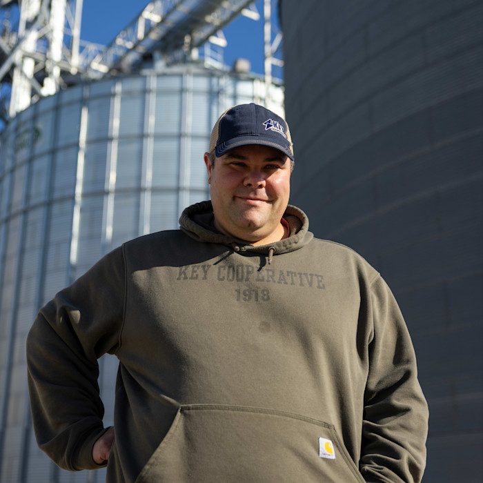 Ben Hollingshead in front of grain bins at Key Cooperative in Kelley, Iowa