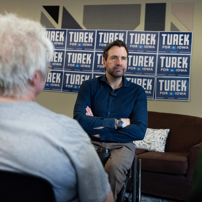 Josh Turek speaks to individuals after he finished speaking at a campaign event in Des Moines, Iowa