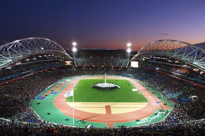 A packed Olympic Stadium at sunset with thousands of spectators attending the Sydney 2000 Olympic Games closing ceremony.