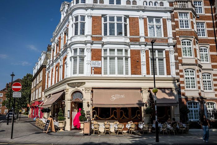 The exterior of Soutine restaurant with outdoor tables and awnings on a street corner in St John's Wood, London.
