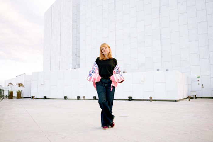 Hanna Harris stands on the rooftop of Finlandia Hall, with the building’s white, geometric facade in the background.