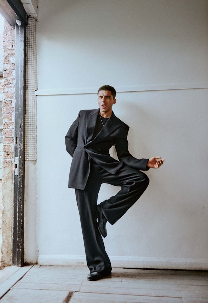 Saint Laurent by Anthony Vaccarello wool crepe jacket, £3,180, matching trousers, £1,365, and cotton T-shirt, £500. Cartier yellow-, white- and rose-gold Trinity necklace, £3,300. Church’s leather shoes, Jay’s own