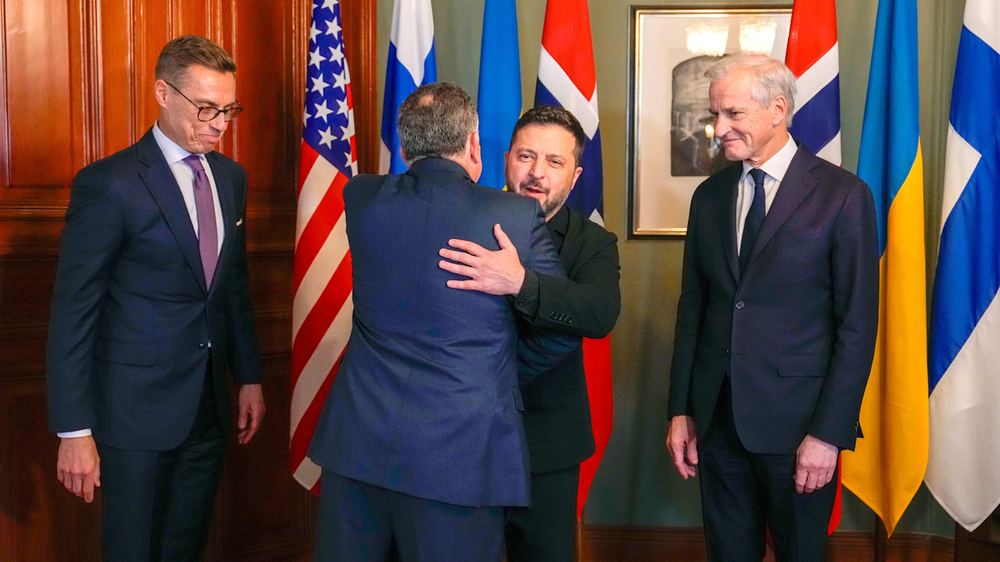 Finnish President Alexander Stubb, US Special Envoy Steve Witkoff, Ukrainian President Volodymyr Zelenskyy and Norway's Prime Minister Jonas Gahr Støre stand together, with Zelenskyy embracing Witkoff