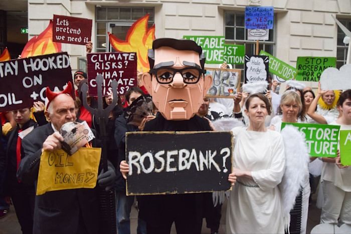 Activists dressed in costumes hold protest signs against the Rosebank oilfield and Jackdaw gasfield outside a government building